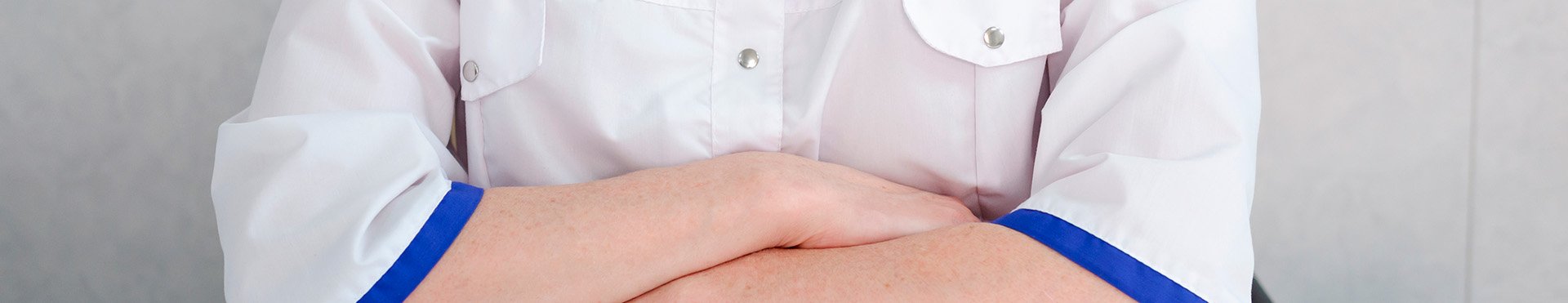 доктор сидит за столом со сложенными руками